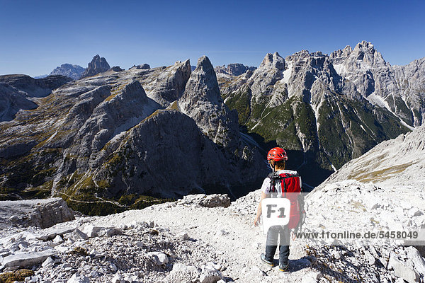 Mountaineer in the Alpinisteig fixed rope route on Mt Einser  Mt Dreischusterspitze at back  Fischleintal below  Hochpustertal Valley  Sexten  Dolomites  South Tyrol  Italy  Europe
