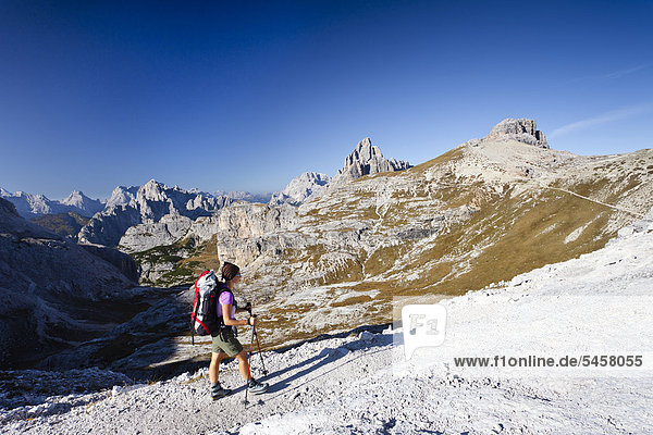 HIkers on Buellelejoch pass during the ascent to Mt Paternkofel above Zsigmondy hut  Mt Paternkofel  Three Peaks and the Cadini range at back  Hochpustertal Valley  Sexten  Dolomites  South Tyrol  Italy  Europe