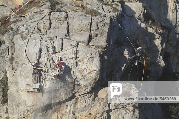 Arbeiter sichern mit Presslufthämmern eine Felswand gegen Felssturz  Absprengen von losem Fels  La Turbie oberhalb von Monaco  DÈpartement Alpes Maritimes  RÈgion Provence Alpes CÙte d'Azur  Frankreich  Europa