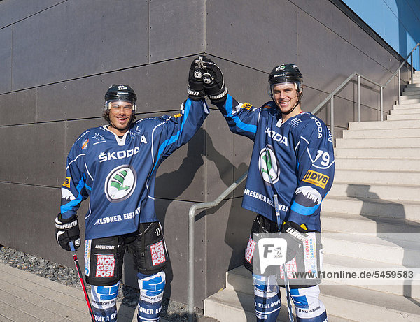 Two ice hockey players  Patrick Strauch  on the left  and Henry Martens  on the right  Dresdner Eisloewen hockey team  exchanging high-fives in front of the EnergieVerbund Arena  Dresden  Saxony  Germany  Europe