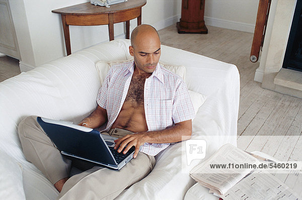 Man studying with laptop on couch