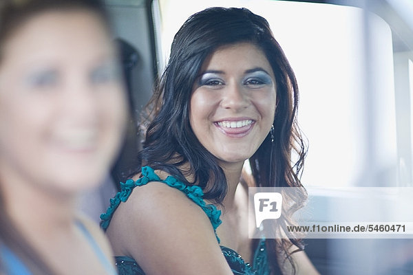 Teenage girl in gown smiling in car