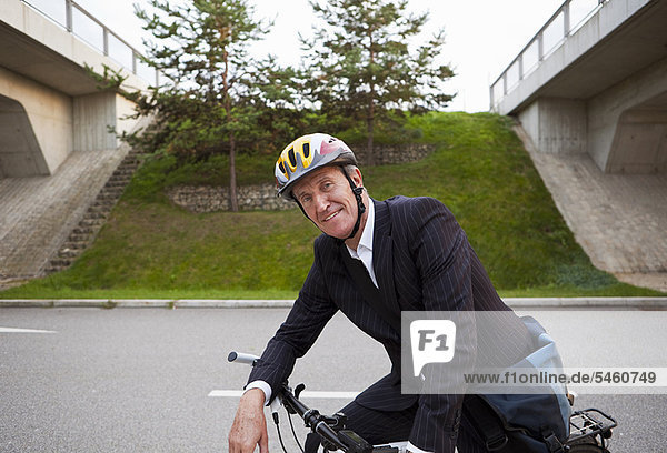 Businessman riding bicycle on street