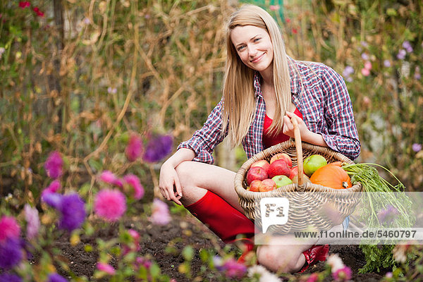 Frau sammelt Gemüse im Garten