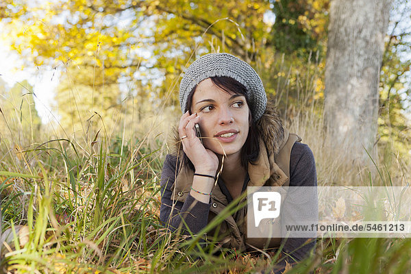 Woman talking on cell phone in park