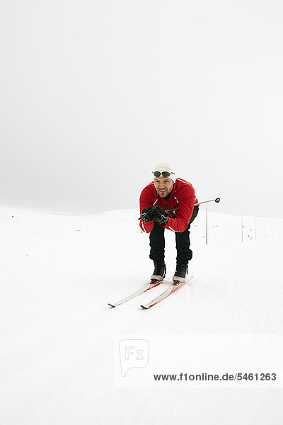 Man crouching while cross-country skiing