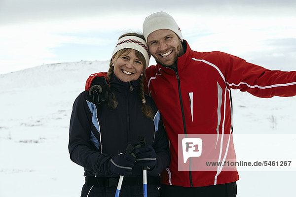 Couple hugging on snowy mountain