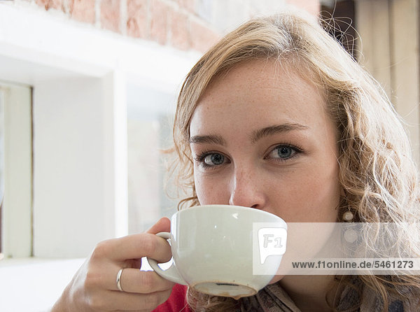 Teenage girl drinking cup of coffee