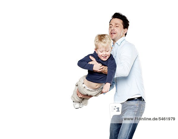 Studio portrait of father playing with son