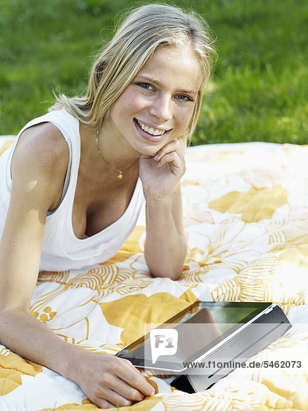 Junge Frau liegen auf Decke mit digital Tablet smiling portrait
