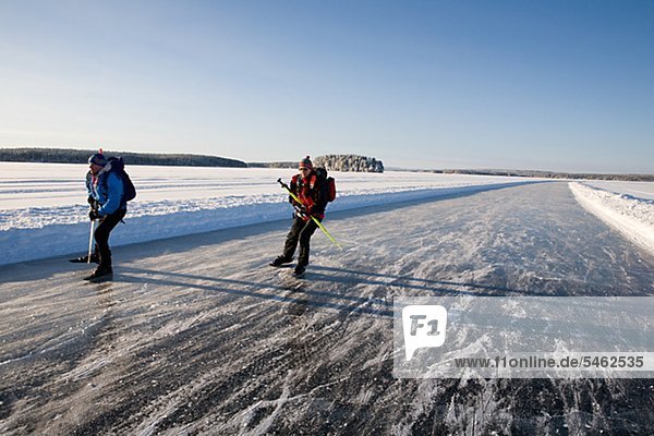 Zwei Skifahrer auf dem Eis verfolgen