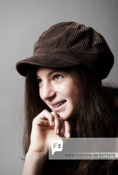 Girl  aged 13  wearing a brown cap  smiling  portrait