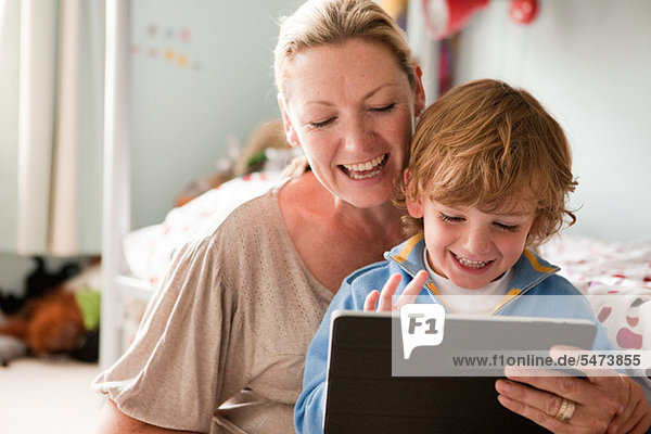 Mutter mit einem digitalen Tablett mit ihrem Sohn