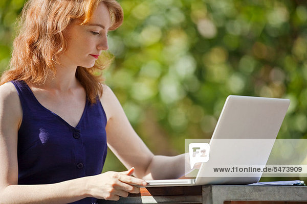 Junge Frau mit einem Laptop außerhalb