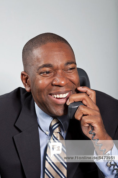 Mature businessman using telephone  smiling