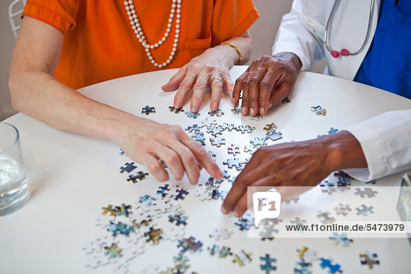 Senior Woman und Arzt mit Jigsaw puzzle