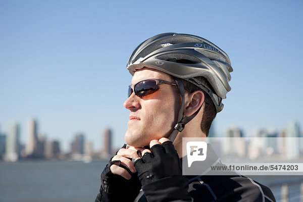 Man adjusting bike helmet strap
