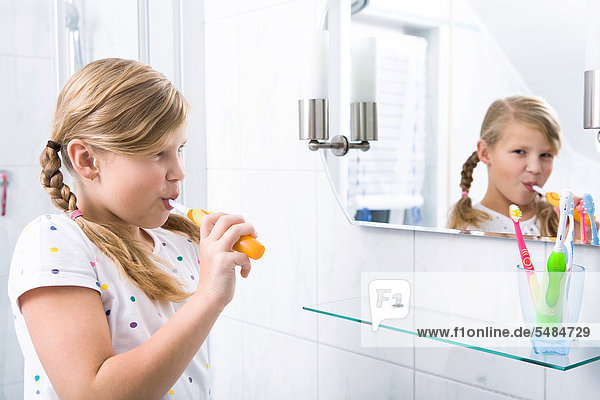 Little girl brushing her teeth in the bathroom