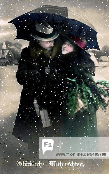 Mann und Frau stehen im Schnee  Regenschirm  Schriftzug Glückliche Weihnachten  historische Illustration