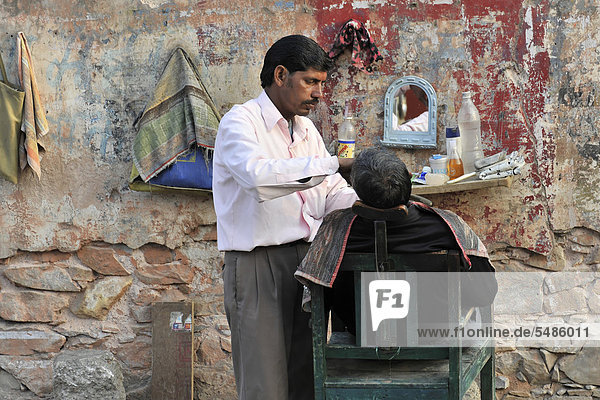 Street barber shaving a man  town centre of Jaipur  Rajasthan  North India  South Asia  Asia