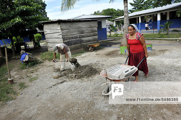 Woman with a heavy wheelbarrow on a construction site  Las Mesitas  Jiquilisco  El Salvador  Central America  Latin America
