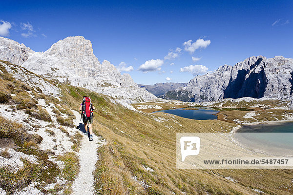 Hiker at the Boedenseen lakes while descending from Three Peaks Hut  Schusterplatte Mountain on the left  Einser Mountain on the right  Croda Rossa di Sesto or Sextener Rotwand at the rear  Sexten  High Puster Valley  Dolomites  Alto Adige  Italy  Europe