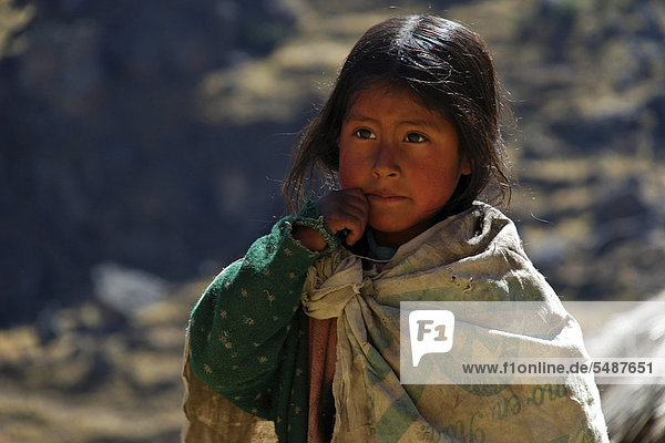 Poor girl of the indigenous peoples dressed in rags portrait near Cusco Andes Peru South America