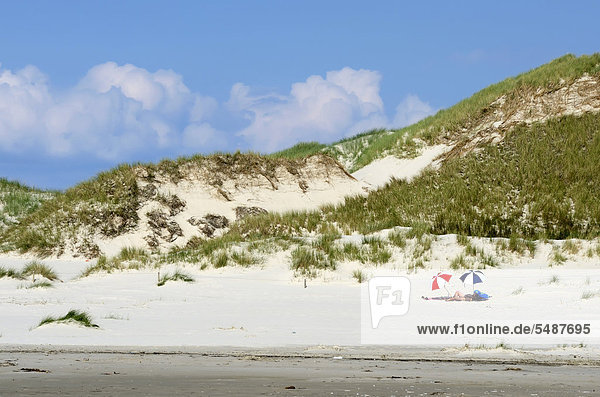 Tourists lying beneath sunshades  dunes at the Kniepsand beach  Amrum Island  Nordfriesland  North Frisia  Schleswig-Holstein  Germany  Europe
