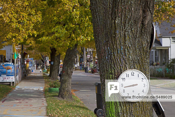 Uhr auf einem Baum  Kunstwerk beim Heidelberg Project  ein Freiluft-Kunstprojekt in einer heruntergekommenen Wohngegend von Detroit  von Künstler Tyree Guyton  Michigan  USA