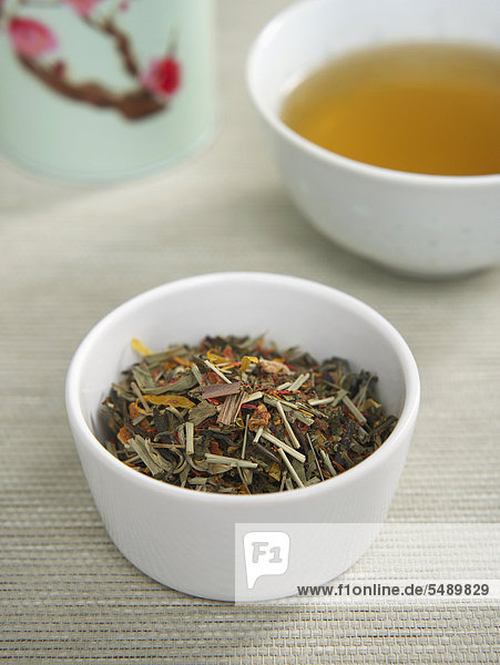 Getrockneter Tee in Schale mit Teetasse