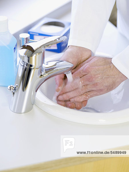 Germany  Hamburg  Doctor washing hands with water  close up
