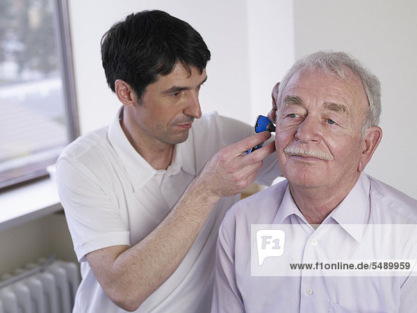 Germany  Hamburg  Doctor examining patient with Otoscope