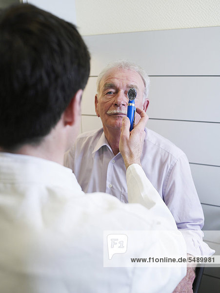 Deutschland  Hamburg  Arzt untersucht Patient mit Otoskop in der Klinik