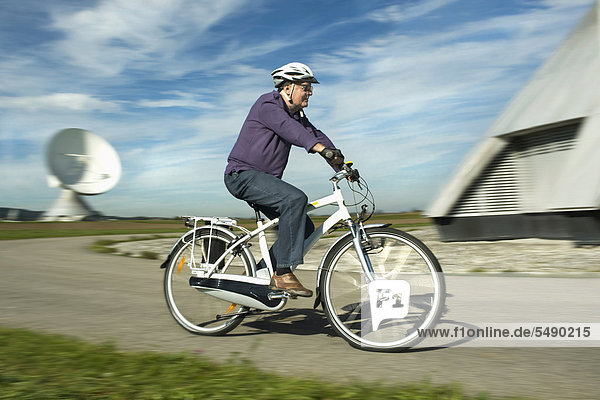 Man riding electric bicycle near radio station