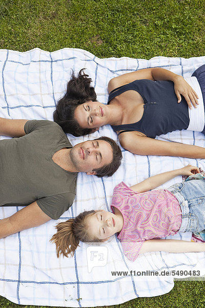 Deutschland  Bayern  Familie entspannt auf Decke im Park