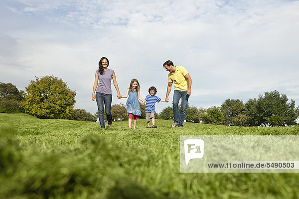 Germany  Bavaria  Family walking in grass at park