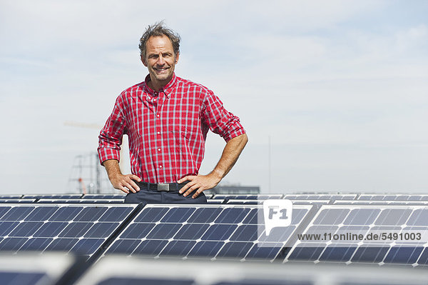 Reifer Mann in Solaranlage stehend  lächelnd  Portrait