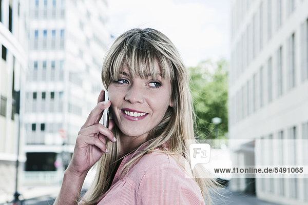 Young woman using cell phone  smiling