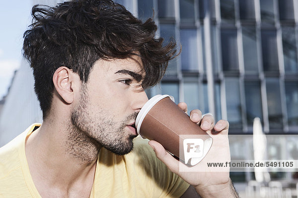 Young man drinking coffee  close up