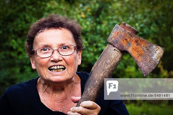 Crazy senior woman holding axe