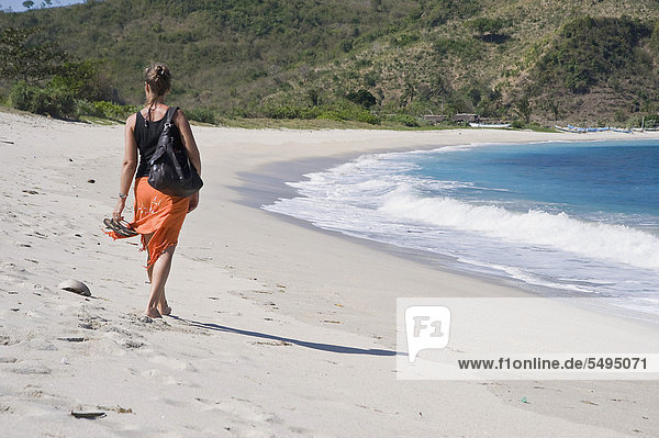 Frau geht einen einsamen Sandstrand entlang  Kuta  Lombok  Indonesien  Südostasien