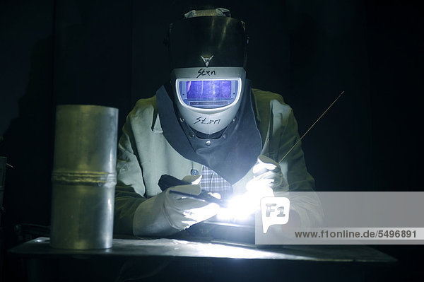Industrial welder wearing protective gear at work
