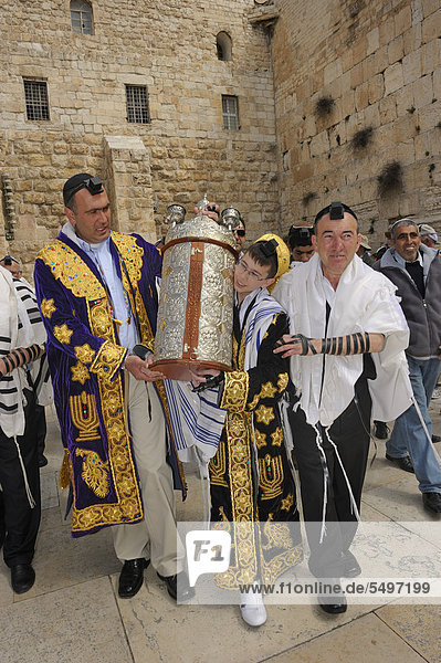 13-year old teenager in festive attire carrying a torah with his relatives from the underground part of the Wailing Wall  synagogue  to the Wailing Wall outside  Arab quarter  Jerusalem  Israel  Middle East