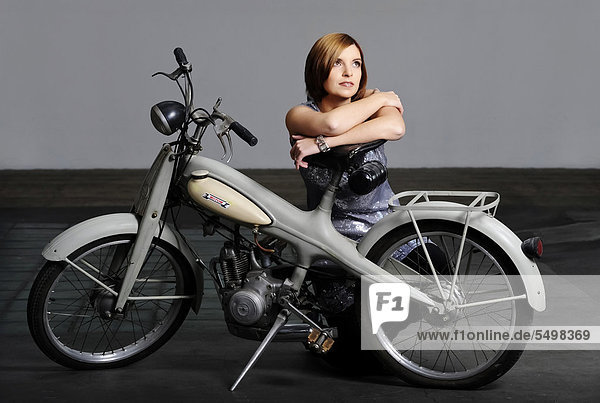 Junge Frau mit Oldtimer-Motorrad  Marke Motom