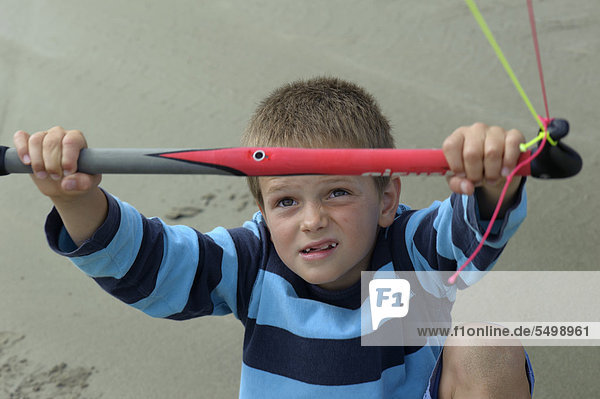 Ein Junge lässt am Atlantikstrand einen Lenkdrachen fliegen  Finistere  Bretagne  Frankreich  Europa  ÖffentlicherGrund