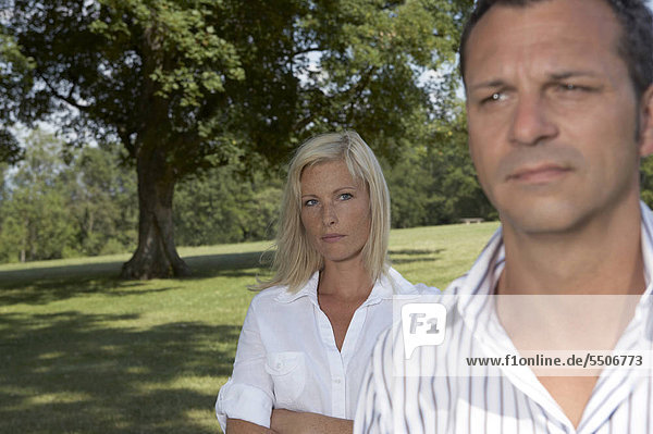 Junges Paar mit ernsten Gesichtern im Park