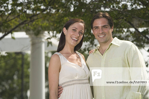 Couple hugging and smiling outdoors