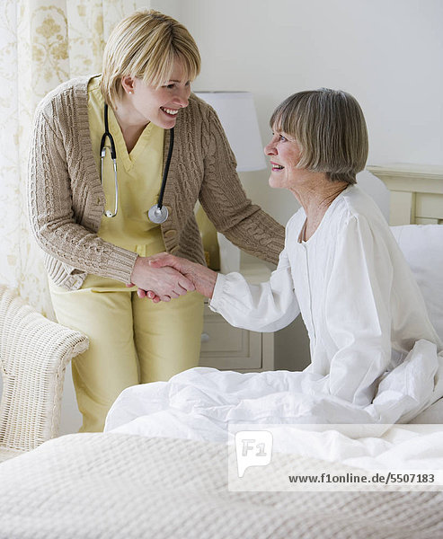 Krankenschwester helfen senior Woman aus dem Bett