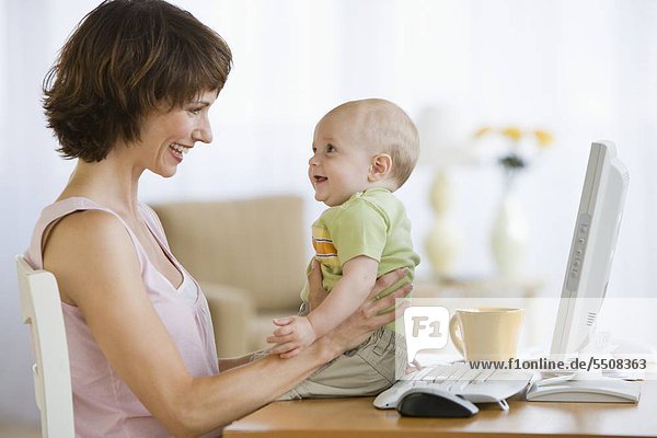 Mutter und Baby lächeln einander