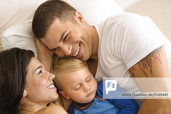 Caucasian Mitte Erwachsenen Eltern mit Kinder Kleinkind Sohn schlafen im Bett kuscheln.
